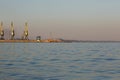 Many big cranes silhouette in the sea port of Azov at golden light of sunset. Mariupol Royalty Free Stock Photo