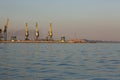 Many big cranes silhouette in the sea port of Azov at golden light of sunset. Mariupol Royalty Free Stock Photo