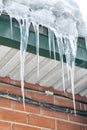 Many big icicles on the winter roof on a sunny day