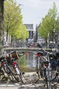 Many bikes are standing near the bridge in Amsterdam. Classic bridge over the canal in Amsterdam. The usual spring day Royalty Free Stock Photo