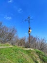 Many birdhouses for birds on one pillar on a hill against a blue sky