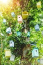 Many birdhouses of different colors on the tree