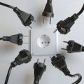 Many Black Electric Plugs are Fighting for Power from the Wall Socket