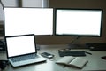 Many blank white screen of computer monitors with accessories and work tools on modern freelance working space Royalty Free Stock Photo