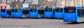 Many blue modern public transport buses are lined up in the parking lot