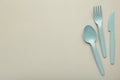 Many blue plasic forks, spoons and knives on grey background with copy space, top view Royalty Free Stock Photo