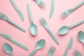 Many blue plasic forks, spoons and knives on pink background with copy space, top view Royalty Free Stock Photo