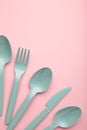 Many blue plasic forks, spoons and knives on pink background with copy space, top view Royalty Free Stock Photo