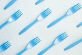 Many blue plastic forks on light background, top view. Disposable tablewear, sorting plastic concept. Creative pattern, flat lay Royalty Free Stock Photo