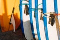 Many blue and white surfing longboard with surf fins and leash ready for rent. Set of multicolored surf boards in a stack by ocean Royalty Free Stock Photo