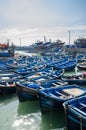 Many blue wooden fishing boats anchored in historic port of medieval town Essaouira, Morocco, North Africa