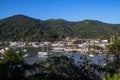 Many boats and yachts anchored in a cozy bay among the lush tropical vegetation against the backdrop of the mountains. Rich luxury