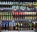 Minsk, Belarus, July 12, 2018: Many bottles of beer of different brands show on a shelf for sale in a supermarket