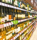 Many bottles of wine on display on the shelves for sale in the store.