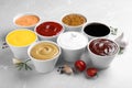 Many bowls with different sauces on light grey table Royalty Free Stock Photo