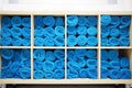 Many bright blue bunch of white towels on shelves