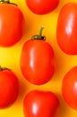Many bright red juicy tomatoes on a yellow background. Royalty Free Stock Photo