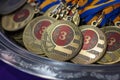 Many bronze medals with copper ribbons and yellow- blue ribbons on a silver tray, Champions awards, achievements in sport, the thi