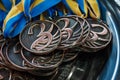 Many bronze medals with copper ribbons and yellow- blue ribbons on a silver tray, Champions awards, achievements in sport, the thi Royalty Free Stock Photo