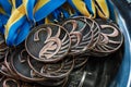 Many bronze medals with copper ribbons and yellow- blue ribbons on a silver tray, Champions awards, achievements in sport, the thi Royalty Free Stock Photo