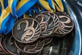 Many bronze medals with copper ribbons and yellow- blue ribbons on a silver tray, Champions awards, achievements in sport, the thi