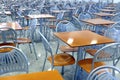 Many brown square eating tables and metal chairs staying in empty cafe hall Royalty Free Stock Photo