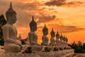 Many buddha statues sitting in row on sunset