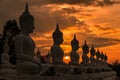 Many buddha statues sitting in row on sunset Royalty Free Stock Photo