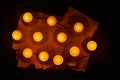 Many burning circle candles and ancient burnt paper sheets Royalty Free Stock Photo