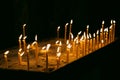 Many burning tall wax candles with bokeh light background. Catholic or Orthodox church. Flame of candles in the dark Royalty Free Stock Photo