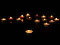 Many burning tealight candles on background