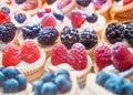 Many cakes with berries. Background of cupcakes with raspberries, blackberries and blueberries