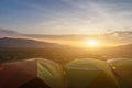 Many camping tent on green field near forest during dramatic sunrise at summer misty morning,Concept of outdoor camping adventure