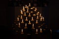 many candles burning in dark in Catholic church, church decoration, bell ringing, concept of Christian religious traditions and