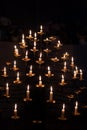 many candles burning in dark in Catholic church, church decoration, bell ringing, concept of Christian religious traditions and