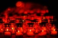 Many candles burning in red candle holders at night Royalty Free Stock Photo