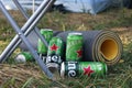 Many cans of Heineken alcoholic beer are set against the backdrop of an outdoor camp