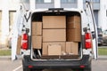 Many cardboard boxes lying in minibus with open door