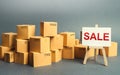 Many cardboard boxes and a sign stand with the word SALE. Sale of goods and products at attractive prices and promotions. big