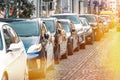 Many Cars parked in row on street in city in sunny summer day. ecological problem - air pollution