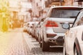 Many Cars parked in row on street in city in sunny summer day. ecological problem - air pollution Royalty Free Stock Photo