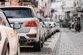 Many Cars parked in row on street in city in sunny summer day. ecological problem - air pollution Royalty Free Stock Photo