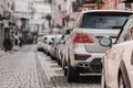 Many Cars parked in row on street in city in sunny summer day. ecological problem - air pollution