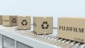 Many cartons with FUJIFILM logo move on roller conveyor. Editorial 3D rendering