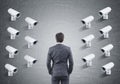 Many CCTV cameras on one wall, rear view of a man Royalty Free Stock Photo