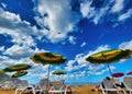 Many chairs and umbrella on sea beach under swaying palms. Blue warm sea water is great for swimming. Beach chairs with umbrellas Royalty Free Stock Photo