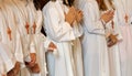 Many children with long white tunic during the first communion