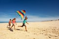 Many children run away with color kite on a beach Royalty Free Stock Photo