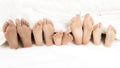 Many children`s feet peeking from under the blanket Royalty Free Stock Photo