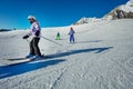 Many children ski on the hill together downhill